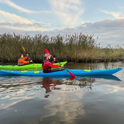 Paddling the Design Kayaks Unplugged sea kayak on calm waters