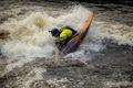 A paddler going vertical with the Pyranha Firecracker on a river